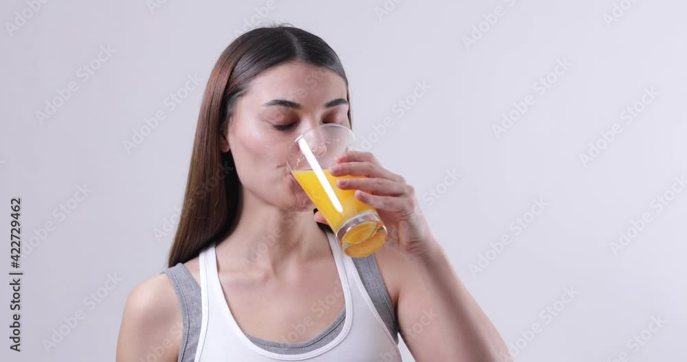 young woman drinking a glass of orange juice young woman drinking a glass of orange juice