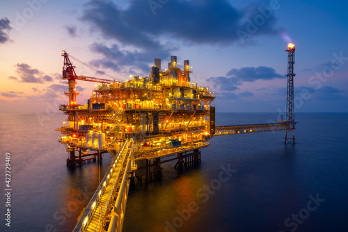 Sunset at Offshore production platform in petroleum industry photo