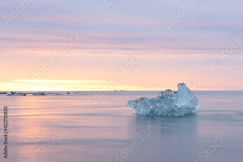 Ice floe in the water by the ocean at sunrise. glacial lagoon. Iceland. long exposure with blurry water.