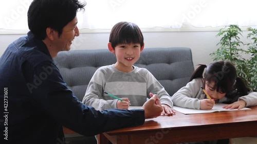 子供たちに勉強を教える父親