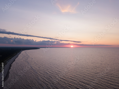 The Gulf of Riga, the Curonian Spit can be seen in the distance. Sunset, quiet summer evening. Photo from the drone.