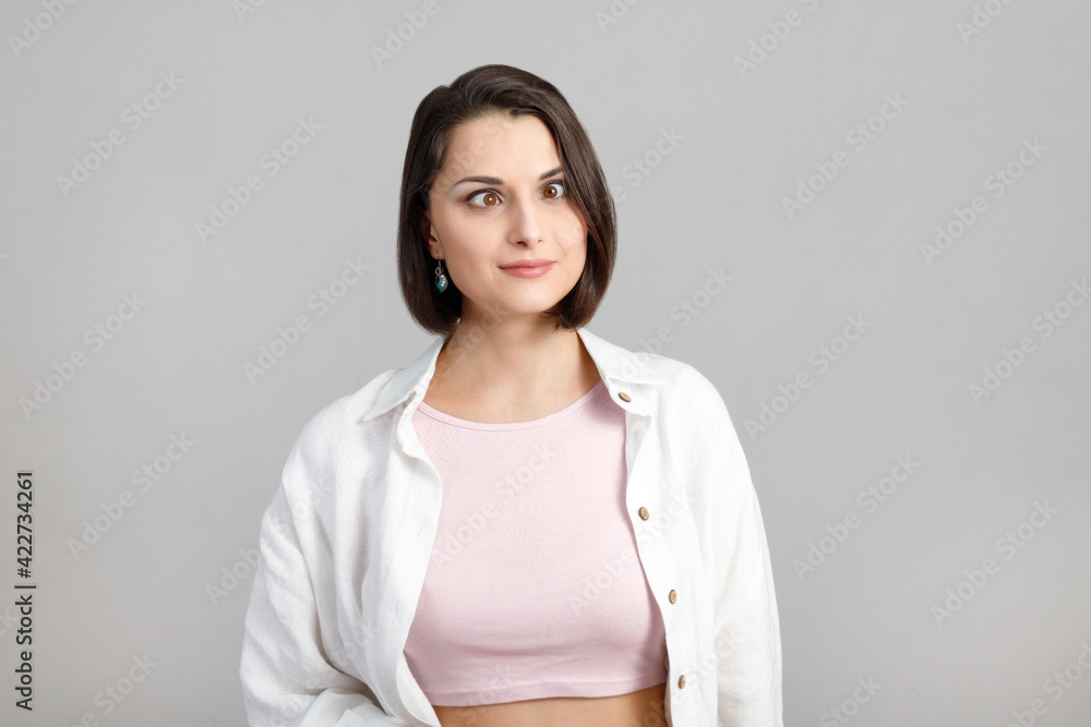 High key portrait of funny brunette multiethnic woman squinted her eyes in pink tank and white shirt High key portrait of funny brunette multiethnic woman squinted her eyes in pink tank and white shirt