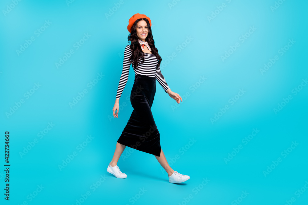 Full size profile side photo of young attractive woman happy positive smile go walk isolated over blue color background