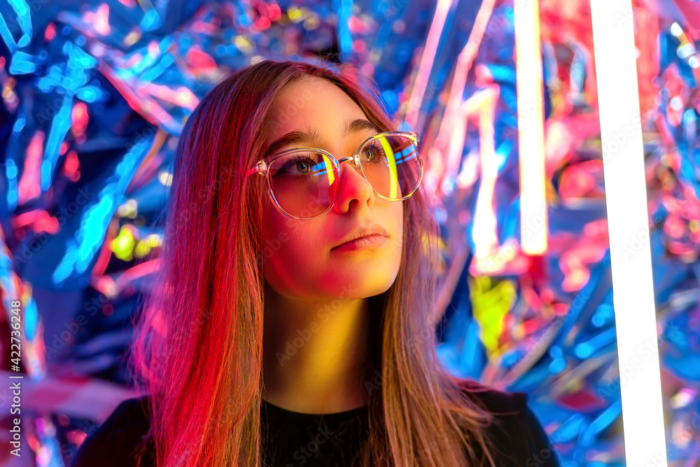 beautiful young girl wearing dark glasses in neon light. portrait of a ...