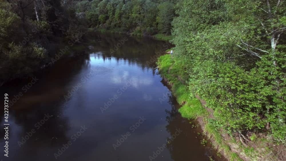 Bird's-eye view of a river and green forests. Flying above curved river surrounded by green forest. Bird's-eye view of a river and green forests. Flying above curved river surrounded by green forest.