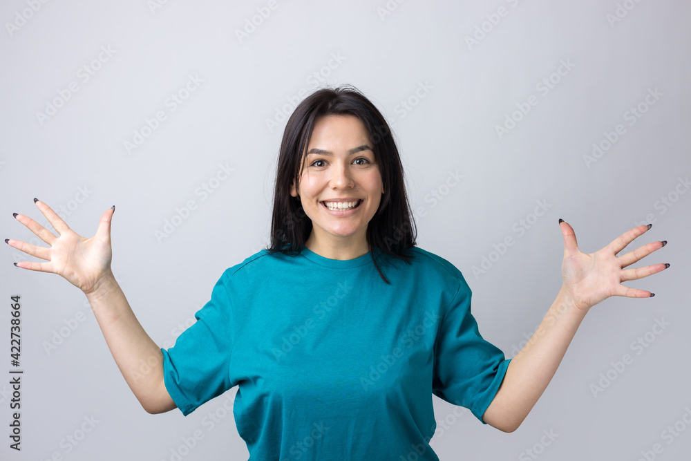 Young beautiful woman with facial expression of surprise standing over gray background. Young beautiful woman with facial expression of surprise standing over gray background.