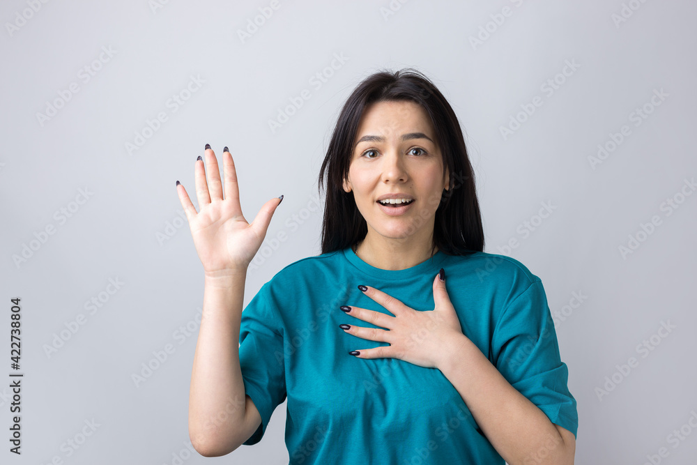 Young beautiful woman with facial expression of surprise standing over gray background. Young beautiful woman with facial expression of surprise standing over gray background.