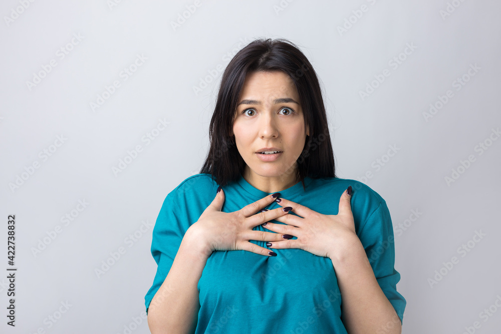 Young beautiful woman with facial expression of surprise standing over gray background. Young beautiful woman with facial expression of surprise standing over gray background.