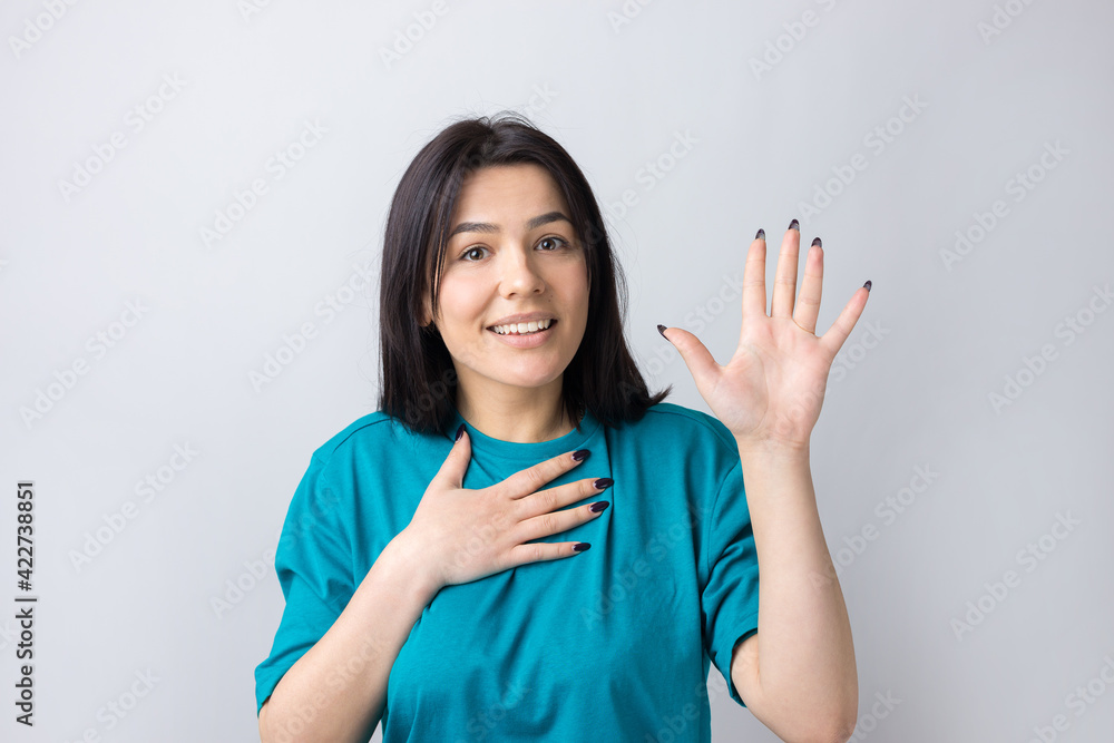 Young beautiful woman with facial expression of surprise standing over gray background. Young beautiful woman with facial expression of surprise standing over gray background.