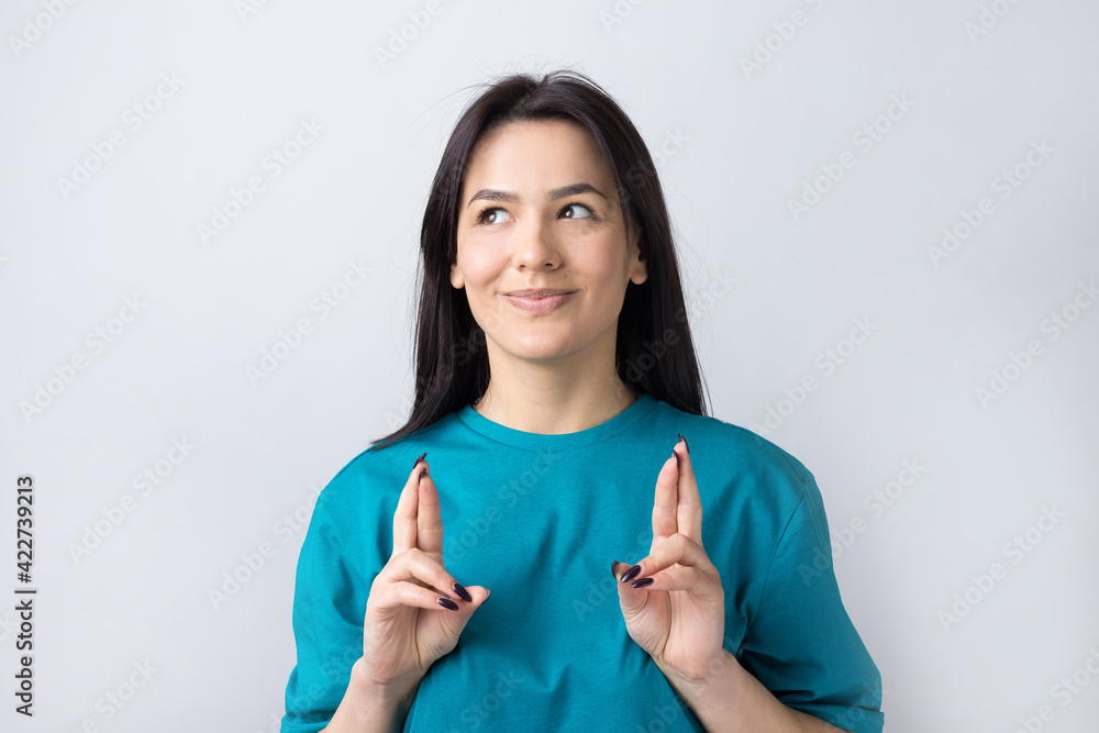 Portrait of wishful young woman crossing her fingers and hopes for luck. Portrait of wishful young woman crossing her fingers and hopes for luck.
