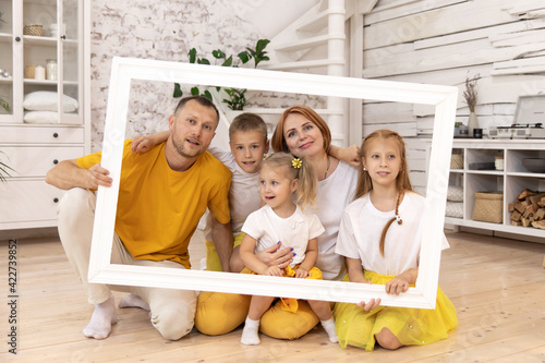 family holding picture frame and smiling