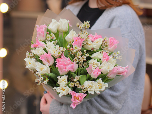 Wallpaper Mural Bouquet of colorful fresh tulips with waxflower. Young woman holding bouquet of fresh tulips and waxflower wrapped in  paper. Torontodigital.ca