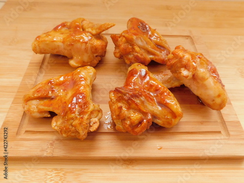 Buffalo BBQ Chicken Wings on wooden table.