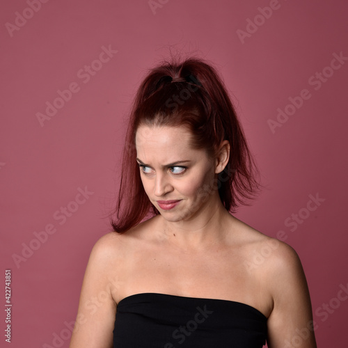 close up portrait of red haired women with different facial expressions on a pink studio background.