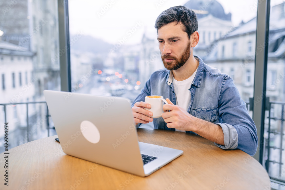 Serious businessman first guest in a cafe, sitting in a coffee s Serious businessman first guest in a cafe, sitting in a coffee s