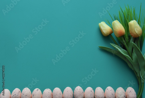 Small eggs and tulips on violet background