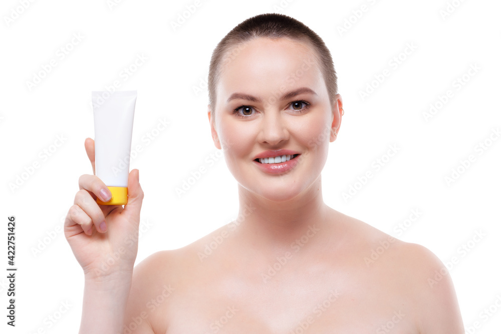 Beautiful woman with bare shoulders and perfect skin showing skincare product Beautiful woman with bare shoulders and perfect skin showing skincare product