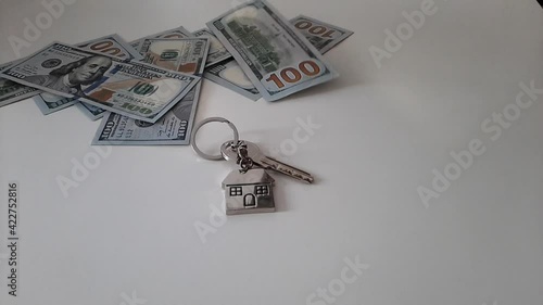 Set of house keys laying on hundred dollar bills