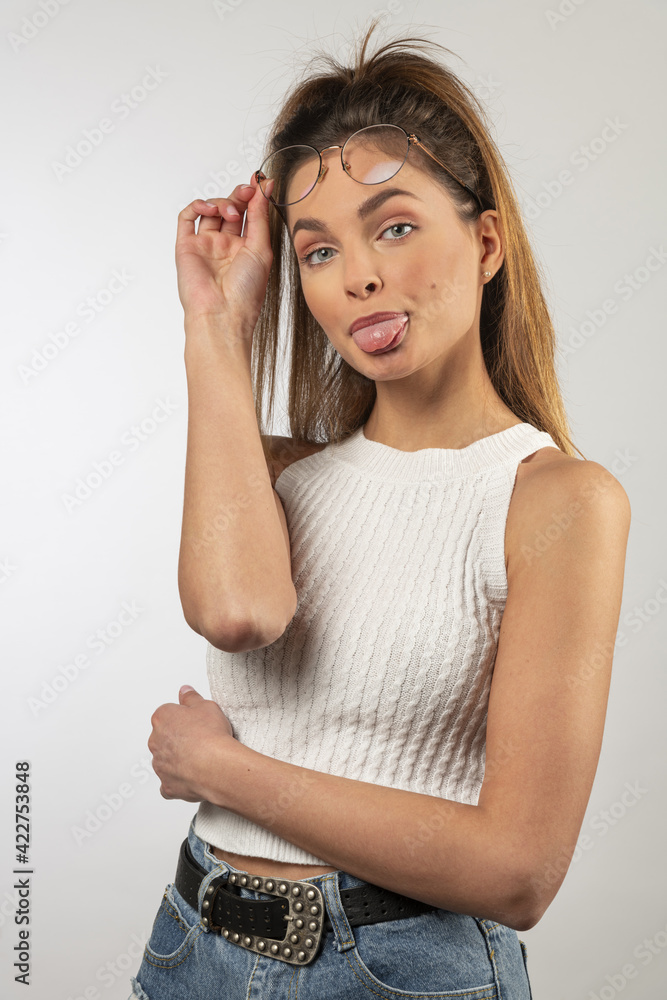 funny portrait of girl looking in camera keeping her eyeglasses and showing toungue funny portrait of girl looking in camera keeping her eyeglasses and showing toungue