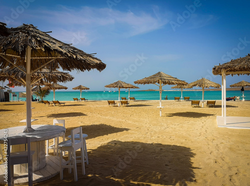 Organic straw umbrellas in a bar in Sal Rei  Cape Verde. Outdoor bar on the beach of Atlantic Ocean. Selective focus on the furniture  blurred background.