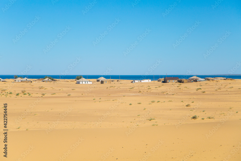 ecological disaster in Central Asia. Sandy desert and a village on the shores of the dry Aral Sea.
