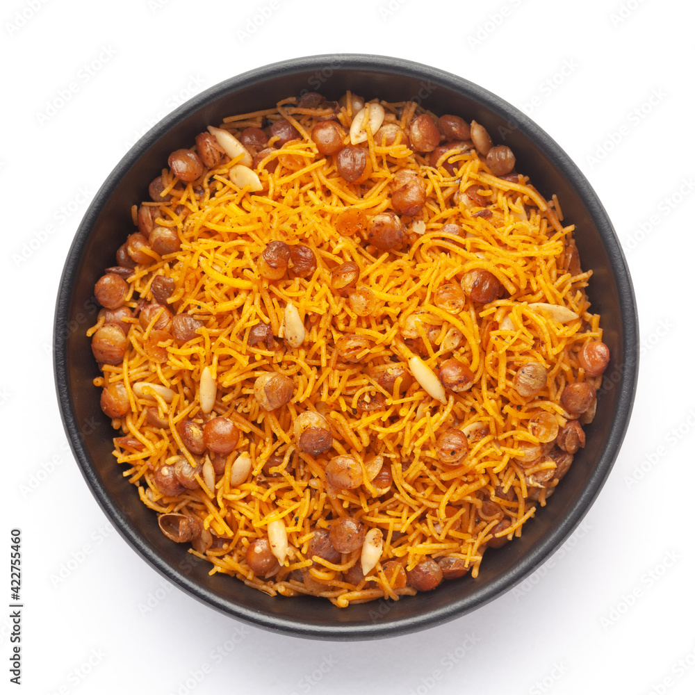 Close-Up Dal Bijli or Dal moth in a black ceramic bowl, made with roasted Masoor Dal (black lentils). Indian spicy snacks (Namkeen), Top View