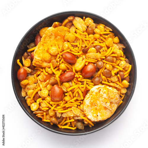 Close-Up of Hot spicy Nav Ratan snacks in a black Ceramic bowl, made with red chili, peanuts. Indian spicy snacks (Namkeen), Top View 