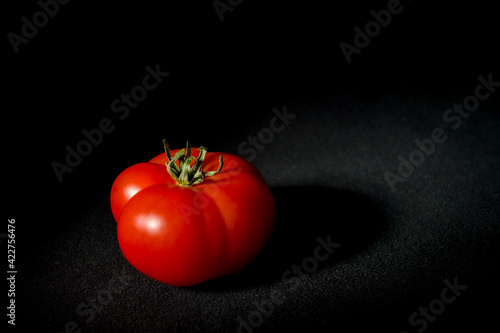 dojrzały czerwony pomidor na czarnym tle