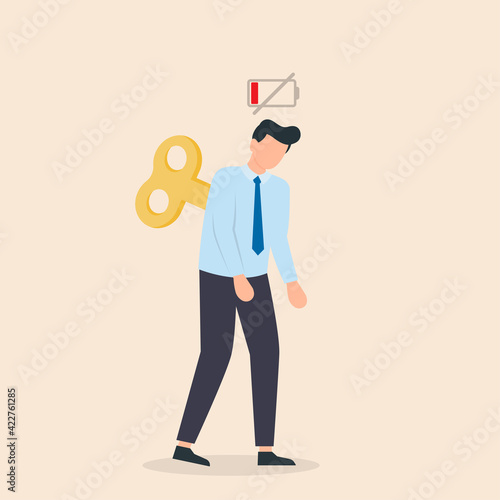 Tired businessman with Clockwork key and empty battery. Professional burnout or long working day concept.