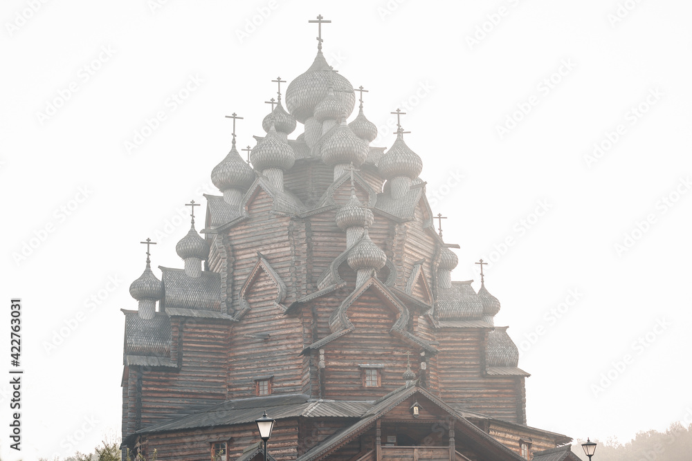 Obraz premium Church in the name of the Protection of the Holy Virgin. Fully wooden church. A masterpiece of ancient architecture. Wooden architecture. The Intercession Church Nevsky Forest Park . St. Petersburg