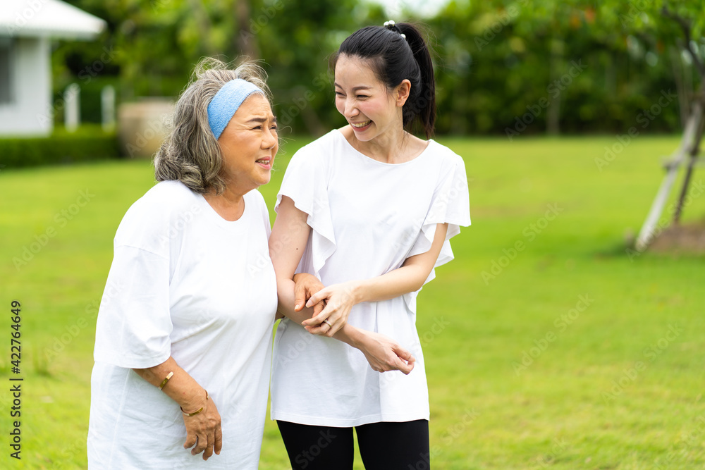 Asian senior mother and adult daughter holding hands and exercise walking outdoor at park. Asian senior mother and adult daughter holding hands and exercise walking outdoor at park.