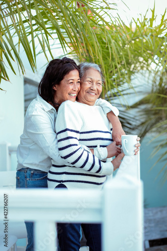 Wall Mural Beautiful senior filipino woman sharing some family time with her daughter