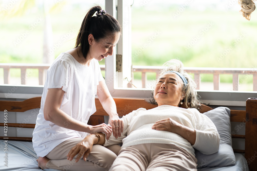 Young Asian daughter takes care of the senior mother who is sick in living room at home