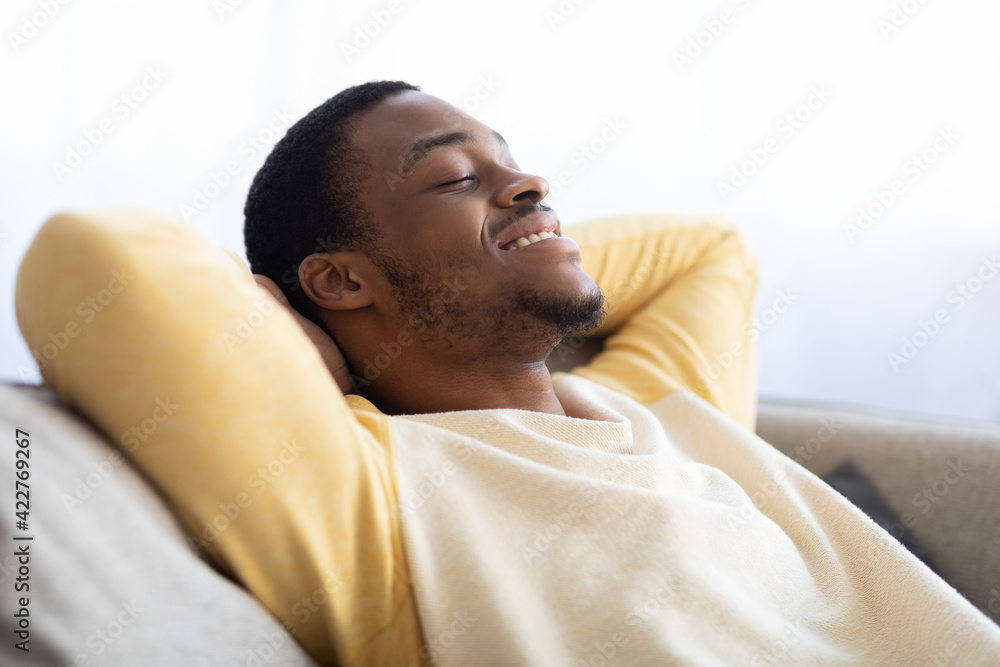 Closeup of black guy relaxing on couch at home Closeup of black guy relaxing on couch at home