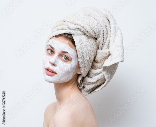 pretty woman grooming white face mask and towel on head