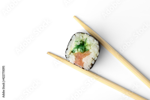 Sishi roll with salmon in chopsticks isolated on white background.