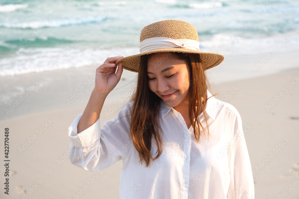 Portrait image of a beautiful young asian woman strolling on the beach by the sea