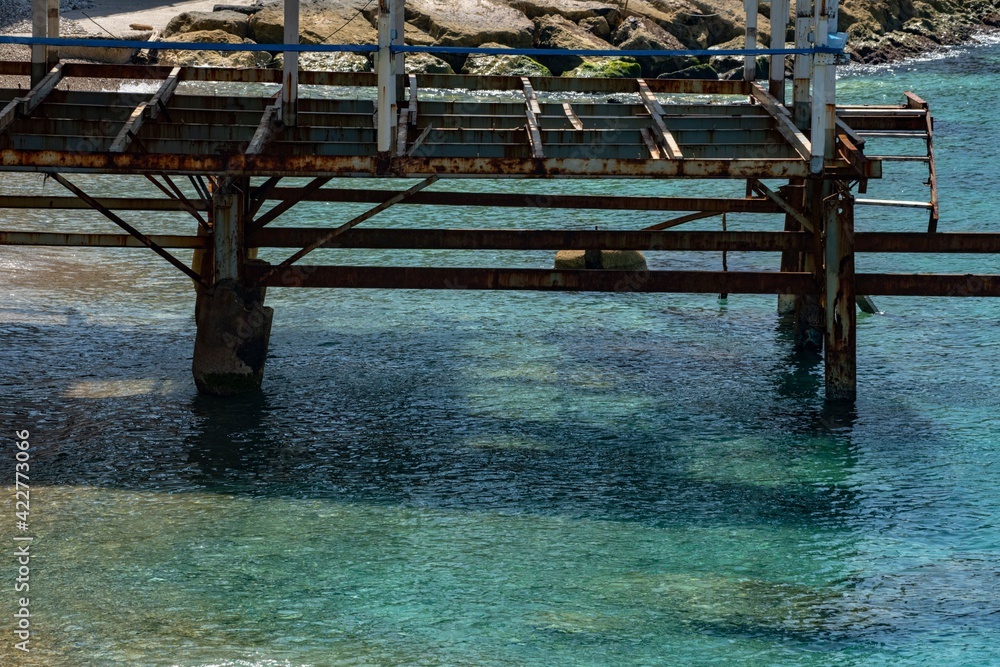 wrecked and abandoned metal frame of a pier in the Mediterranean sea