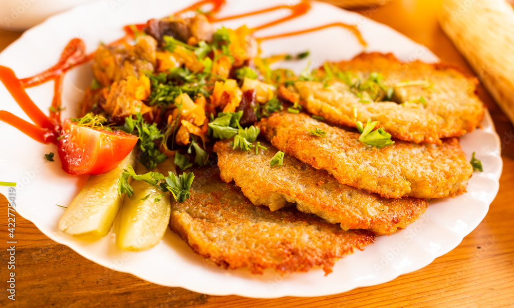 potato pancakes with grilled beef dish on a white plate potato pancakes with grilled beef dish on a white plate