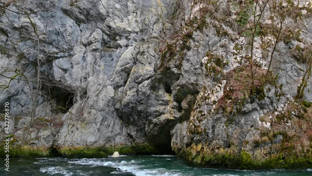 Beautiful and colorful river flowing in rocky canyon. Amazing karst landscape in Slovenia. Unica river near Planina cave. Tilt down, real time