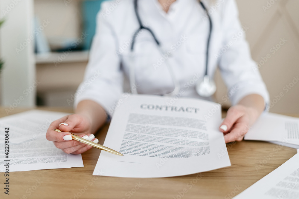 Woman doctor showing insurance contract on camera Woman doctor showing insurance contract on camera