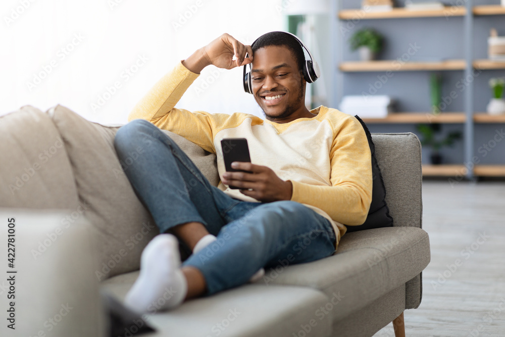Happy black guy watching videos on mobile phone