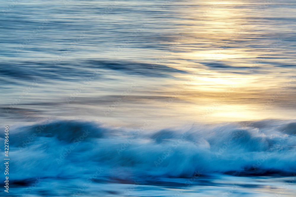 the waves of the sea during the sunset