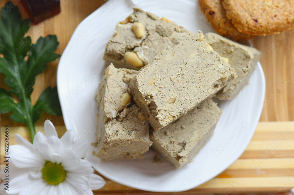 Flat lay a eastern sweets, halva on a white plate and a wooden background. Food. Delicious. Homemade sweets concept. Flat lay a eastern sweets, halva on a white plate and a wooden background. Food. Delicious. Homemade sweets concept.