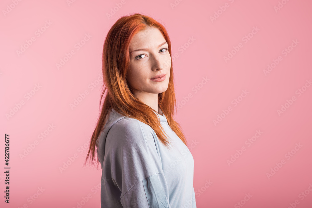 Portrait of a satisfied redhead girl in the studio on a pink background Portrait of a satisfied redhead girl in the studio on a pink background