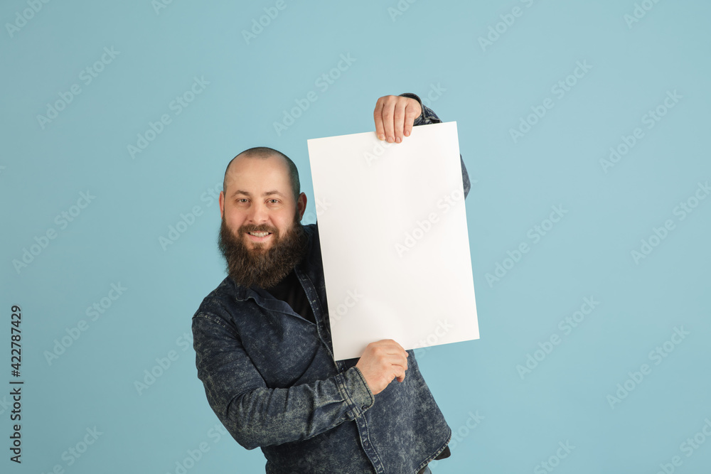 Handsome caucasian man portrait isolated on blue studio background with copyspace Handsome caucasian man portrait isolated on blue studio background with copyspace