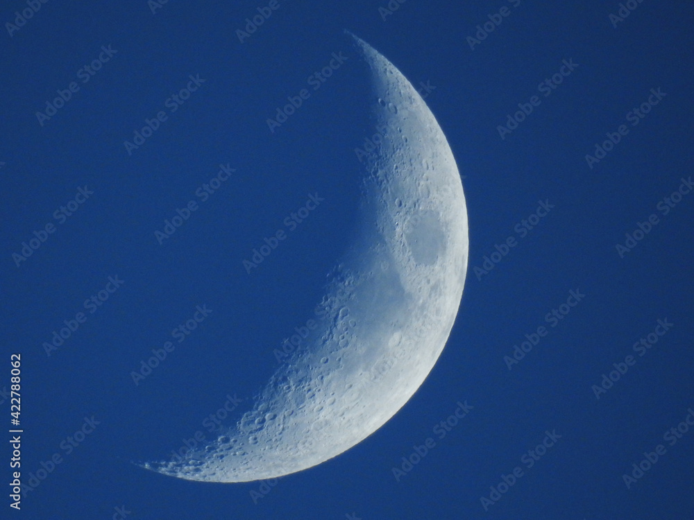 The moon in the waxing crescent phase on a blue background The moon in the waxing crescent phase on a blue background