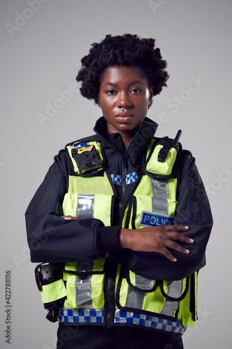 Foto Studio Portrait Of Serious Young Female Police Officer Against Plain Background