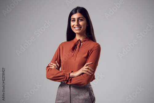 Studio Portrait Of Smiling Young Businesswoman With Folded Arms Against Plain Ba Fototapet