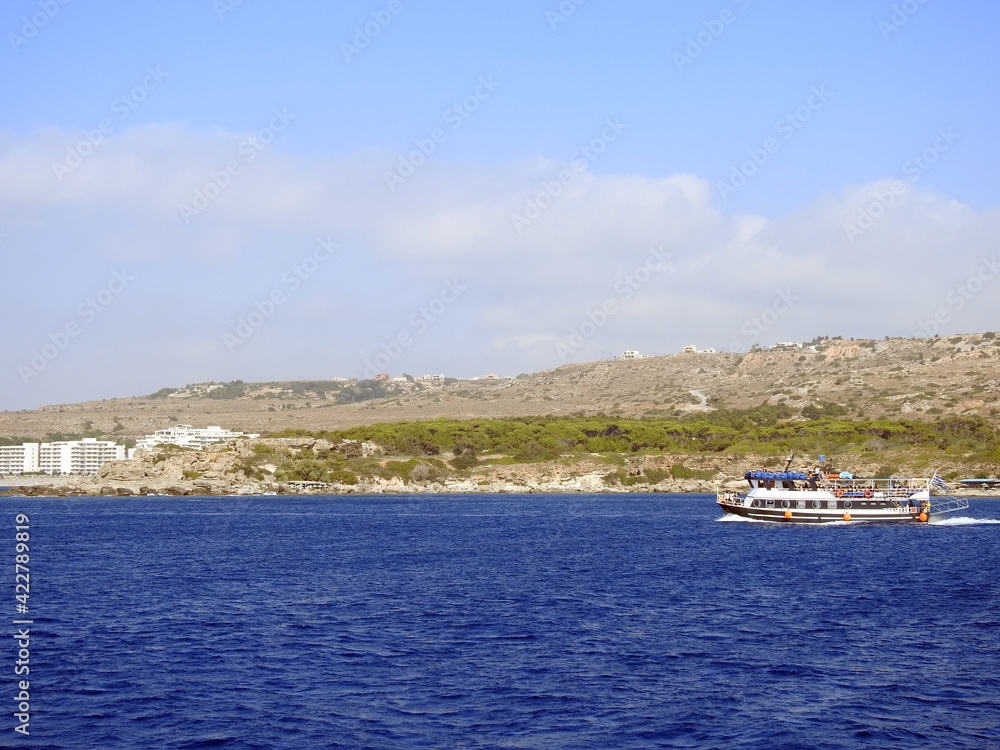 Boat in the sea and rocky land with buildings